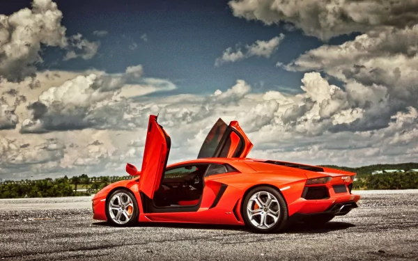 A striking Lamborghini Aventador LP 700-4 in vibrant red with doors open, set against a dramatic sky, making for an impressive HD desktop wallpaper and background.
