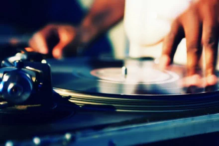 A close-up of a DJ's hands working on vinyl records, showcasing the art of music mixing. This HD desktop wallpaper brings dynamic energy to any background.