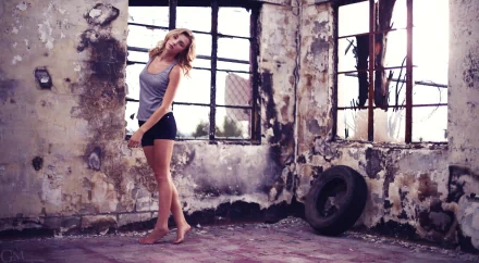 HD PC desktop wallpaper featuring a woman, Rachel Ann Yampolsky, posing barefoot in a worn, industrial-style room with large broken windows and peeling walls.