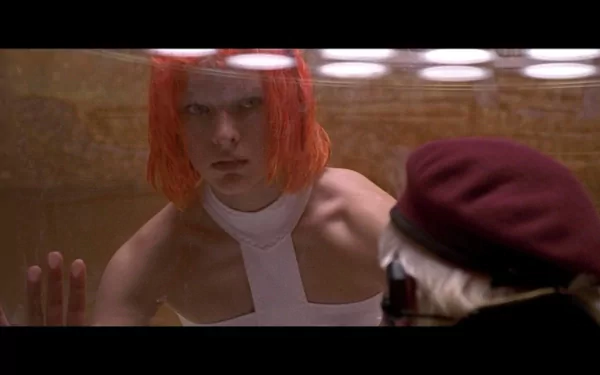 Leeloo (The Fifth Element) presses a hand to glass in a vivid HD movie wallpaper — bright orange hair, white outfit, tense cinematic close-up.