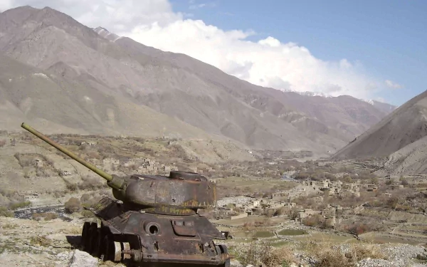 HD desktop wallpaper featuring a military T-34 tank positioned in a rugged mountainous landscape under a partly cloudy sky.