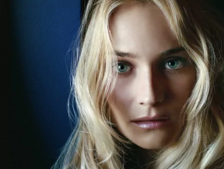 A close-up of Diane Kruger, featuring her striking blue eyes and softly tousled blonde hair, set against a dark background. This image serves as a high-definition PC desktop wallpaper.