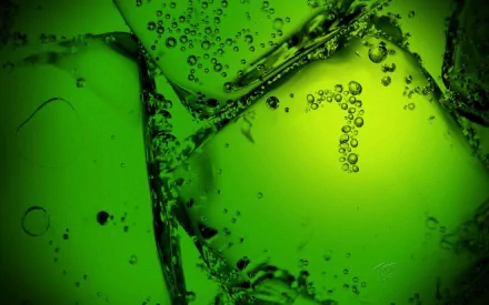 Close-up HD wallpaper of man-made ice cubes with bubbles inside, immersed in vibrant green 7up liquid.