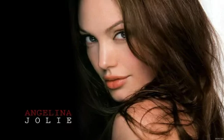 A stunning HD wallpaper featuring Angelina Jolie, capturing her captivating gaze and soft features against a dark background.