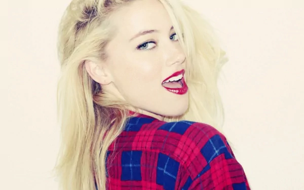 A vibrant HD desktop wallpaper featuring Amber Heard, showcasing her playful expression with a red lip and a stylish plaid shirt against a soft background.