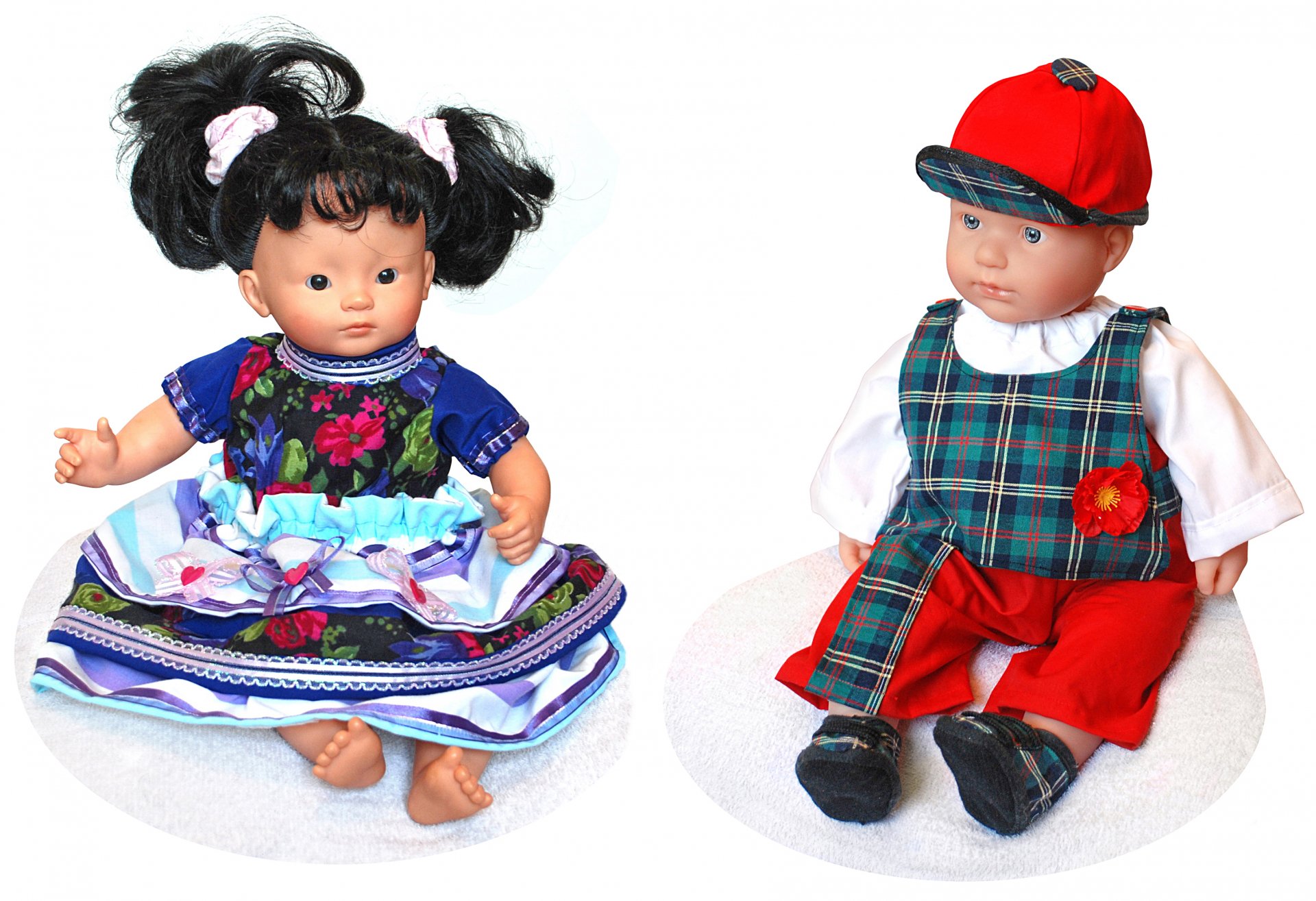 Two man-made dolls: a girl in a colorful embroidered dress and a boy in a red cap and tartan outfit on a white backdrop — 2K Quad HD PC desktop wallpaper.