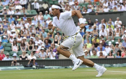 HD desktop wallpaper featuring Rafael Nadal in action on a tennis court during a professional match, surrounded by an enthusiastic crowd.