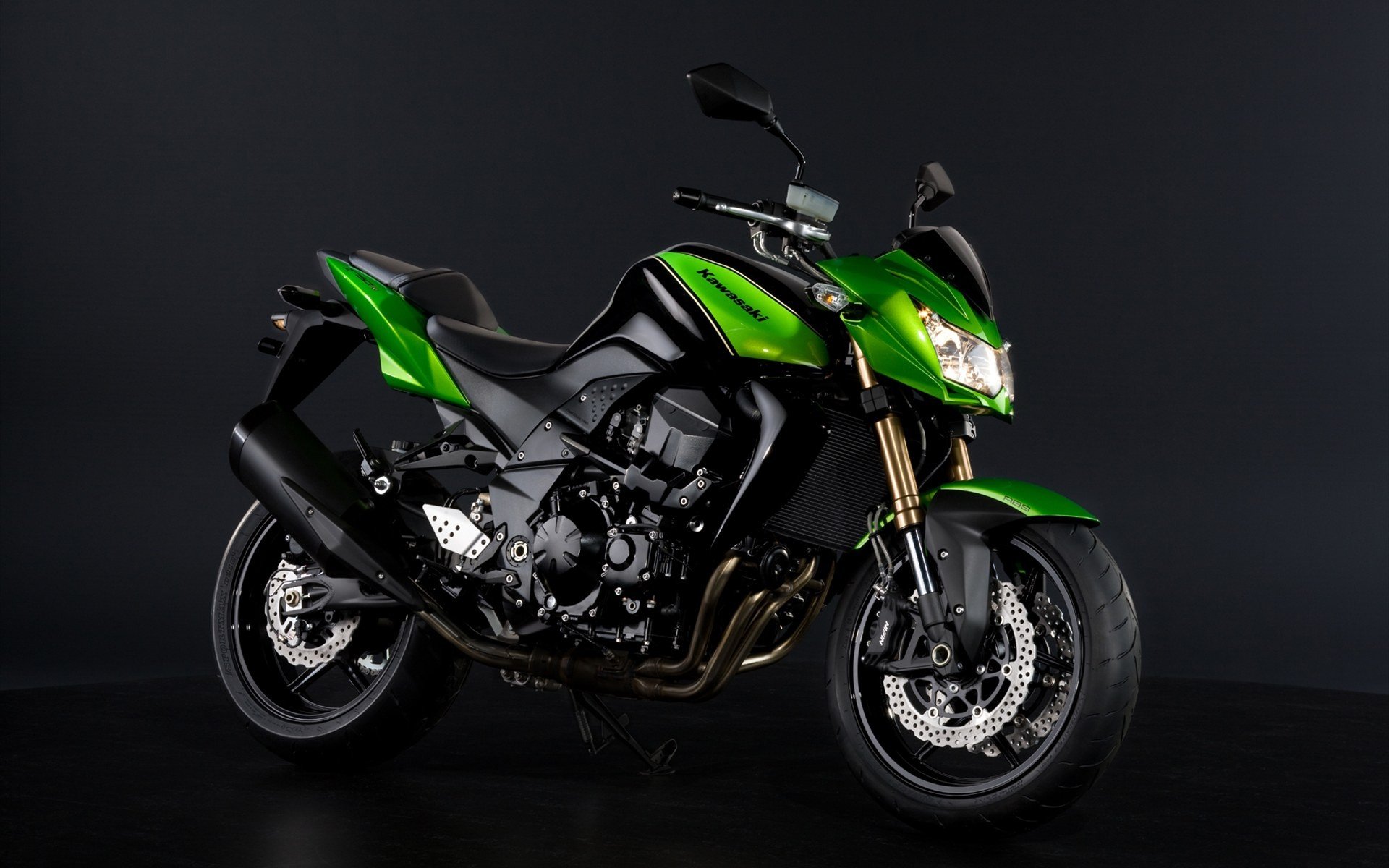 HD desktop wallpaper featuring a sleek green and black Kawasaki motorcycle against a dark background.