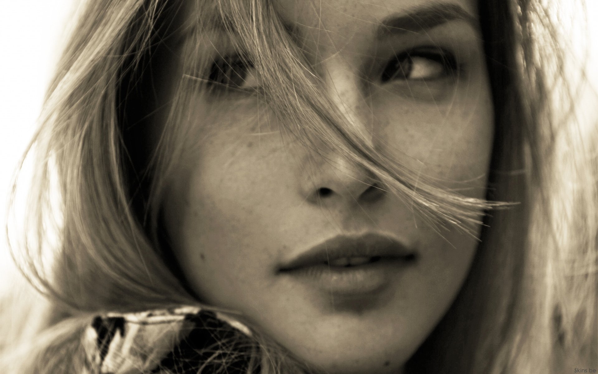 HD PC desktop wallpaper: close-up sepia portrait of a celebrity model with windblown hair, subtle freckles and a soft, contemplative expression.