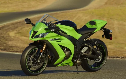 HD desktop wallpaper featuring a green Kawasaki Ninja motorcycle parked on a paved surface with a blurred grassy background.