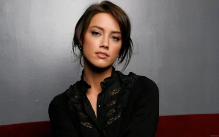 HD desktop wallpaper featuring celebrity Amber Heard against a neutral gray background, dressed in a black top with lace accents.