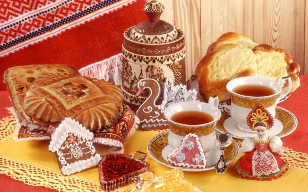 Still life HD desktop wallpaper featuring tea, bread, viennoiserie, cookies, and jam arranged on a lace cloth with ornate cups and a decorative pot.