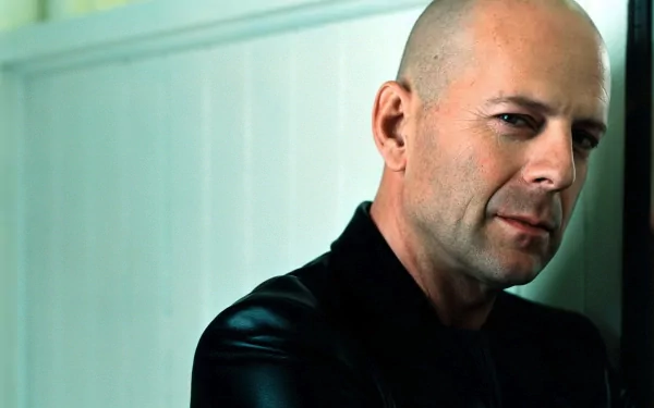 A striking HD desktop wallpaper featuring celebrity Bruce Willis. He leans casually against a wall, exuding confidence and a cool demeanor.
