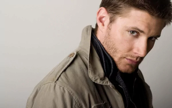 HD PC desktop wallpaper featuring a close-up portrait of celebrity Jensen Ackles wearing a jacket and looking over his shoulder.