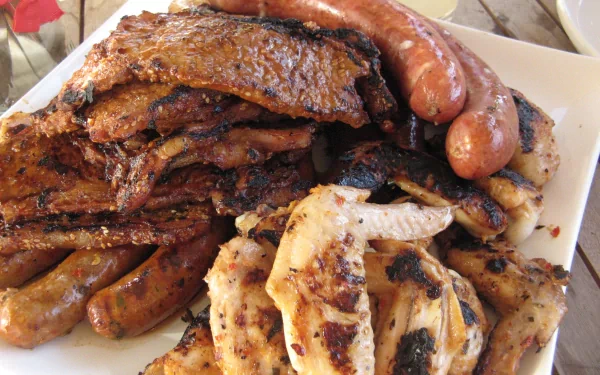 Food/meat HD PC desktop wallpaper: close-up platter of assorted grilled meats — charred ribs, sausages and sliced chicken.