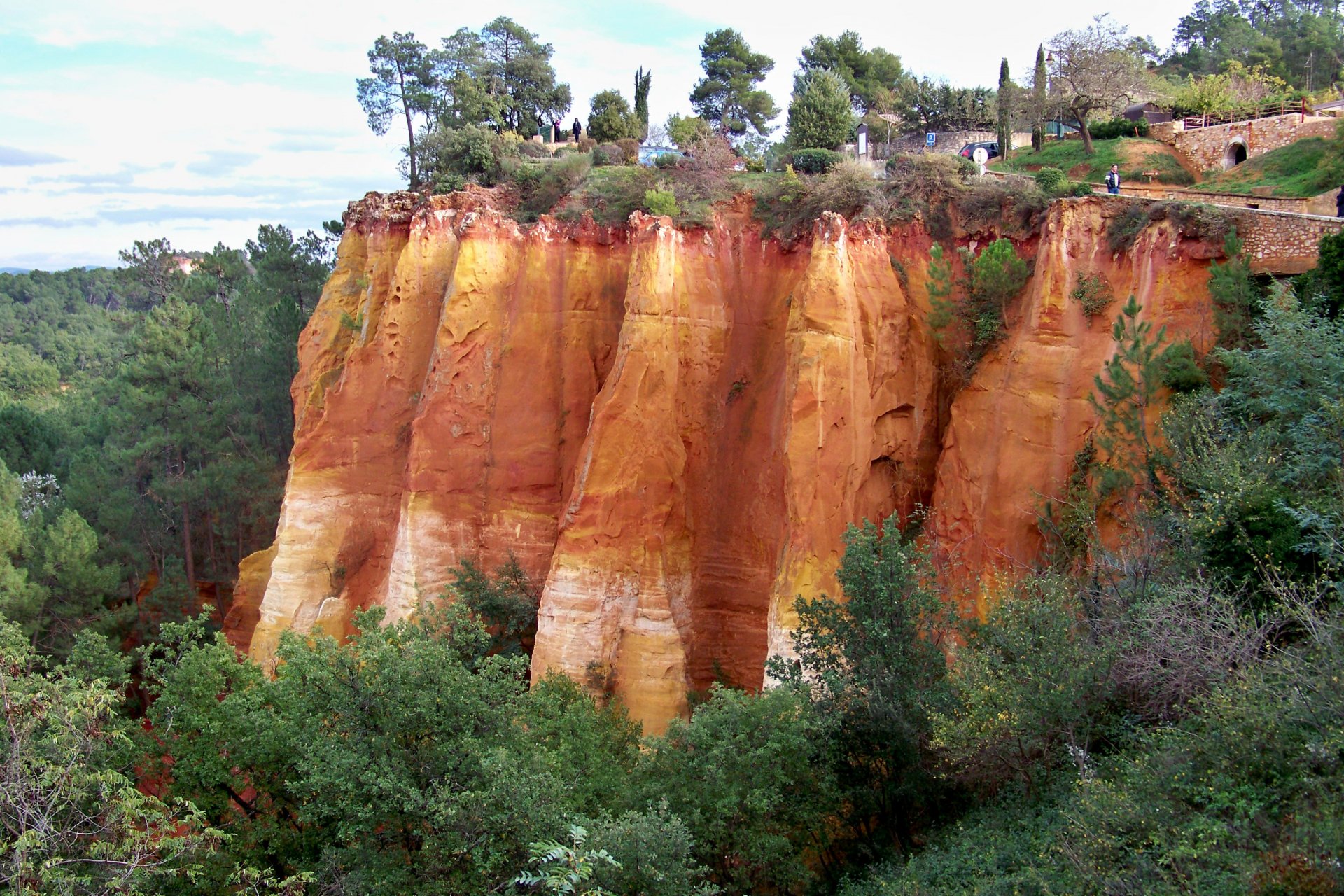 HD landscape photography of vibrant orange rock cliffs surrounded by green trees, captured as a desktop wallpaper and background.
