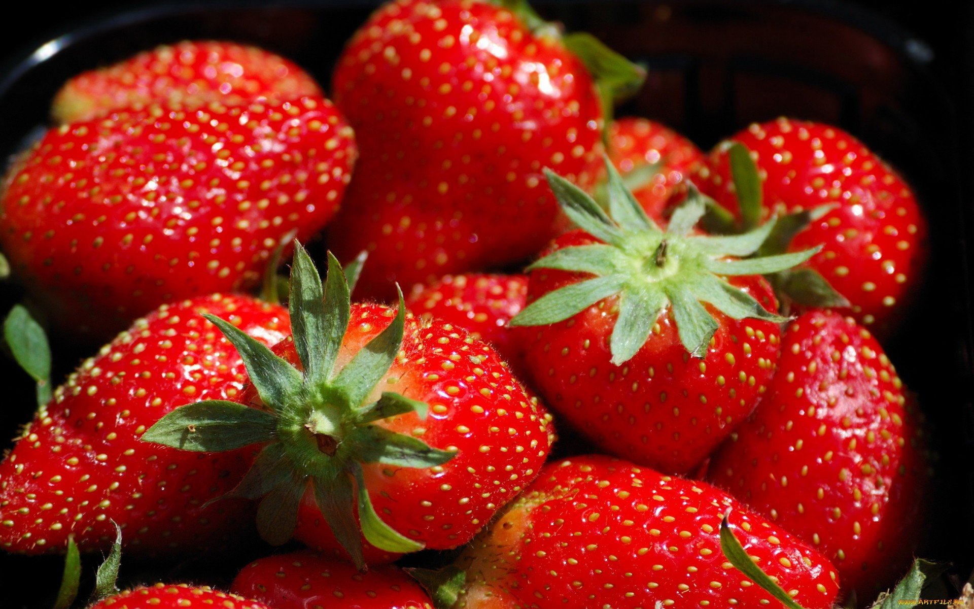 HD PC desktop wallpaper featuring a close-up of fresh, vibrant red strawberries highlighted against a dark background, emphasizing their texture and color.