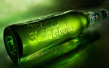 A vibrant HD wallpaper featuring a green Carlsberg beer bottle, beautifully illuminated against a soft green background, celebrating the essence of food and drink.