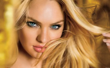 A stunning HD wallpaper featuring Candice Swanepoel, showcasing her striking blue eyes and flowing blonde hair against a warm, golden background.