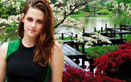 HD desktop wallpaper featuring Kristen Stewart in a garden with blooming flowers and a serene pond in the background.