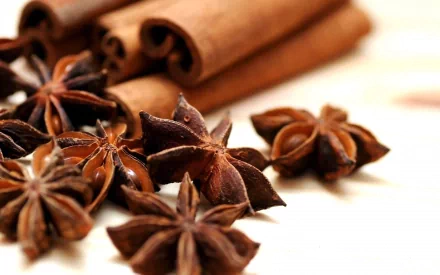 Close-up of anise stars and cinnamon sticks, showcasing rich textures and warm brown tones, presented as an HD PC desktop wallpaper featuring herbs and spices.