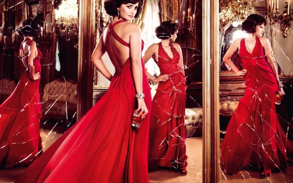 A stunning image of Penelope Cruz in a flowing red gown, surrounded by mirrors, showcasing her elegance and glamour. This HD wallpaper captures a captivating moment.