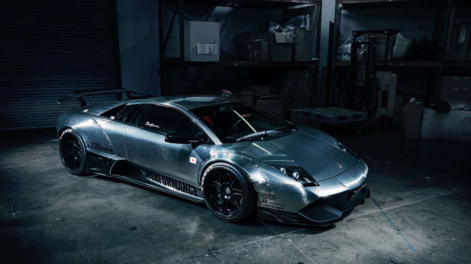 HD desktop wallpaper of a sleek silver Lamborghini Murciélago parked in a dimly lit garage, highlighting its aerodynamic design and glossy finish.