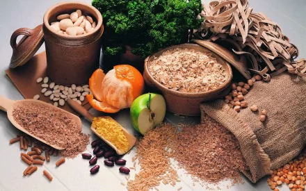 HD desktop wallpaper featuring a still life of various seeds, grains, beans, and fresh produce arranged on a rustic wooden surface.