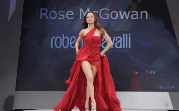 HD desktop wallpaper featuring celebrity Rose McGowan confidently walking a runway in a flowing red gown.