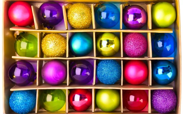 A vibrant assortment of Christmas ornaments in various colors and textures, arranged neatly in a box, capturing the festive spirit of the holiday season. 4K Ultra HD quality.