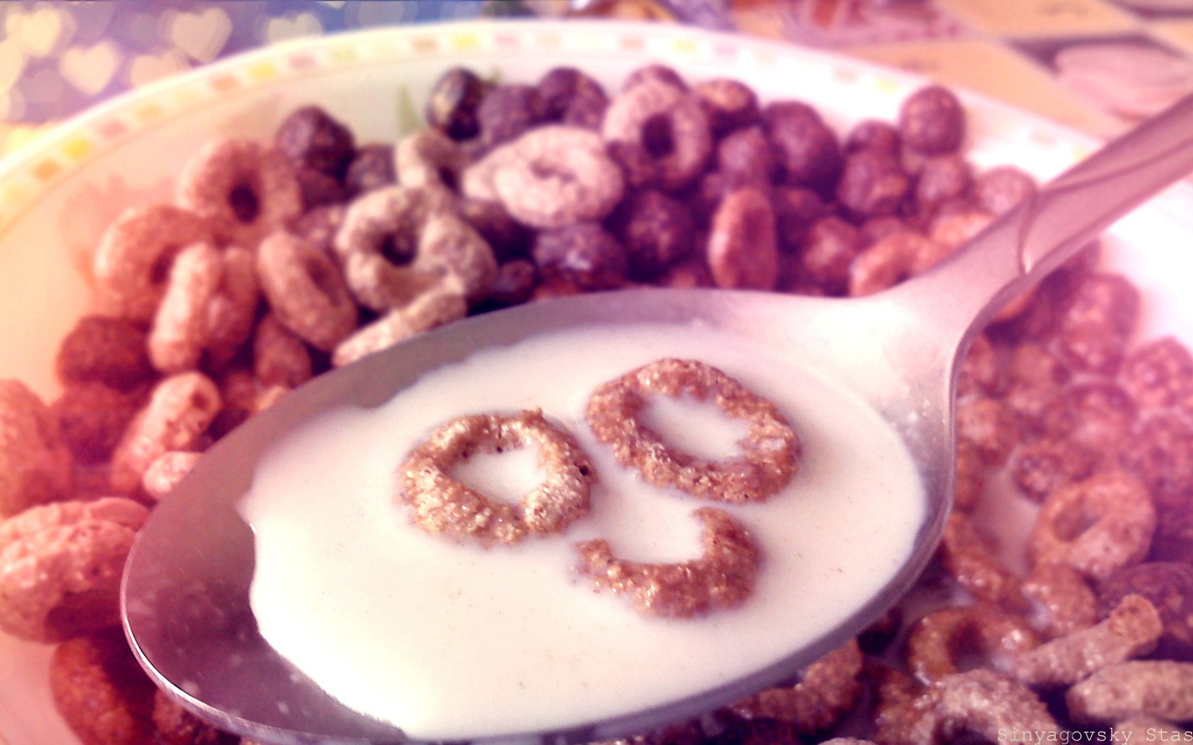 HD desktop wallpaper showing a close-up of a spoon with milk and cereal loops, surrounded by a bowl of multicolored cereal rings.