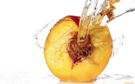 HD desktop wallpaper featuring a close-up of a juicy peach being splashed with water against a white background, highlighting freshness and vibrant color.