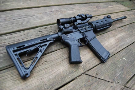 A close-up view of a man-made assault rifle resting on wooden planks, showcasing its sleek design and features for a high-definition desktop wallpaper.