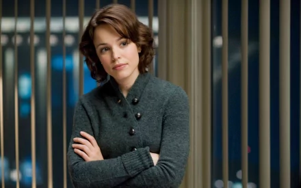 Rachel McAdams poses thoughtfully in a stylish top, framed by sleek blinds in this HD desktop wallpaper, capturing her captivating presence as a celebrated actress.