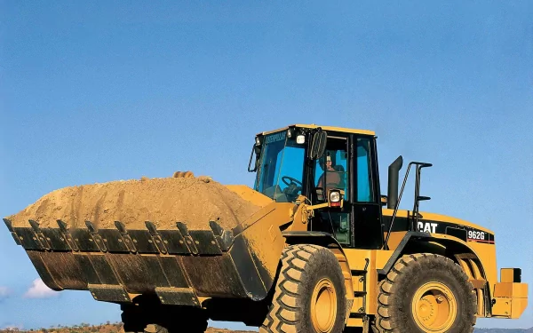 HD desktop wallpaper of a Caterpillar Inc. heavy-duty vehicle lifting a large load of sand under a clear blue sky.