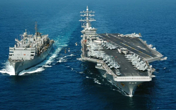 Aerial view of the USS Dwight D. Eisenhower (CVN-69) aircraft carrier and a naval support ship sailing side by side on the open sea, military warship HD wallpaper.