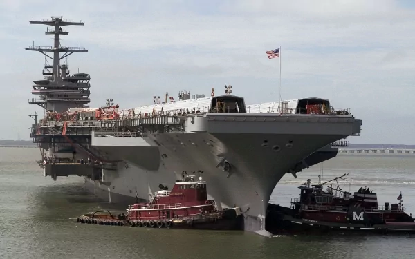 USS George H.W. Bush (CVN-77) aircraft carrier docked, with tugboats alongside, set against a cloudy sky as a HD military warship desktop wallpaper.