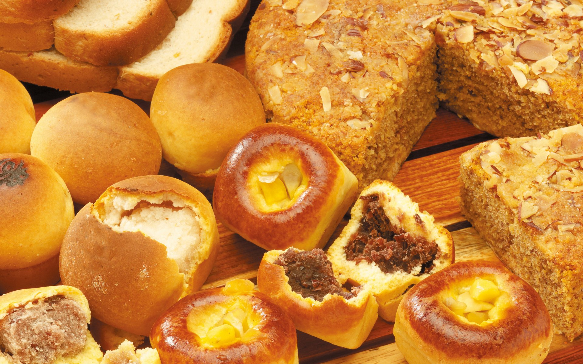 HD PC desktop wallpaper featuring an assortment of freshly baked bread and pastries, showcasing delicious textures and golden crusts in a warm, inviting food baking scene.