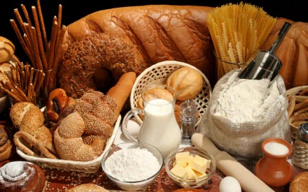 A vibrant HD image showcasing an array of baking ingredients including butter, flour, milk, and various types of bread, beautifully arranged for a culinary backdrop.