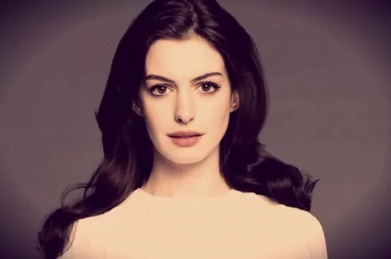 A high-definition desktop wallpaper featuring Anne Hathaway, showcasing her with long, dark hair and a neutral expression against a soft background.
