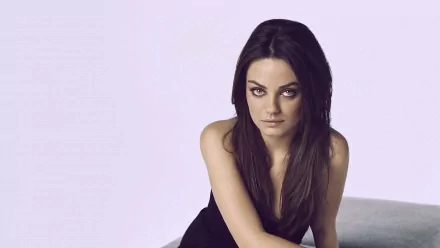 Close-up of Mila Kunis, a brunette celebrity with long hair and brown eyes, smiling gently. This HD image serves as an engaging desktop wallpaper.