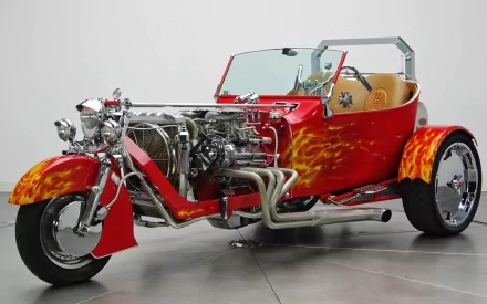 A vibrant red Ford T-Bucket trike with flame designs and chrome accents, showcasing a powerful engine and sleek wheels, makes a striking HD desktop wallpaper for hot rod enthusiasts.