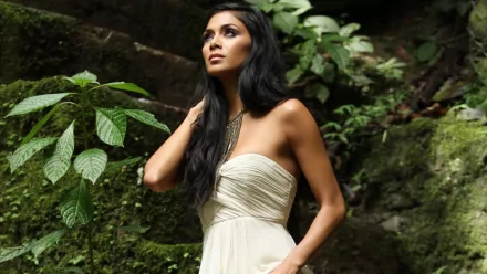 HD desktop wallpaper featuring Nicole Scherzinger in a white dress, set against a lush green natural background, representing music and elegance.