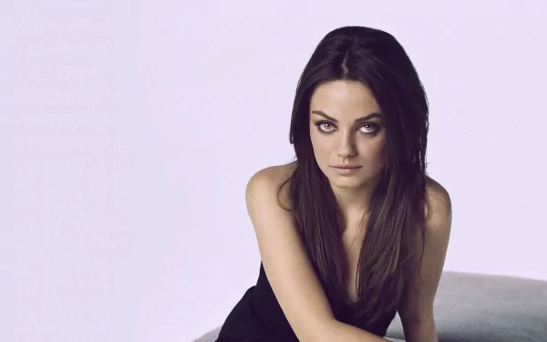 Close-up of Mila Kunis, a brunette celebrity with long hair and brown eyes, smiling gently. This HD image serves as an engaging desktop wallpaper.