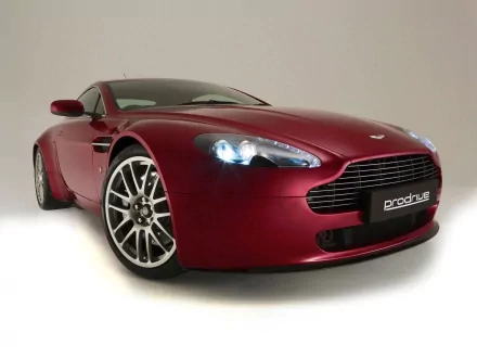 HD PC desktop wallpaper of a red Aston Martin Vantage sports car shown at a low front-left angle on a clean, neutral background.
