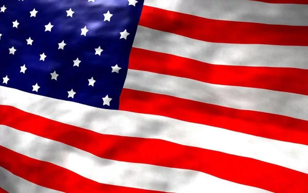 A high-definition desktop wallpaper featuring the American flag, showcasing its vibrant red, white, and blue colors with stars and stripes elegantly flowing.