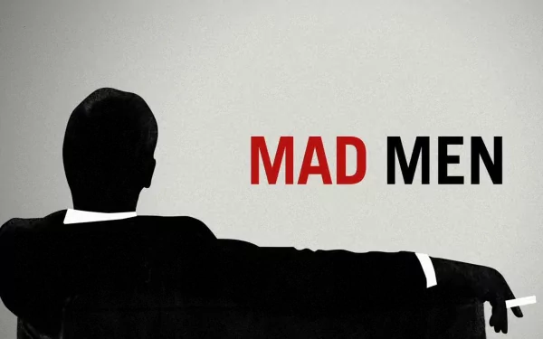 HD PC desktop wallpaper featuring a silhouette of a man sitting on a couch with the red and black Mad Men TV show title on a gray background.
