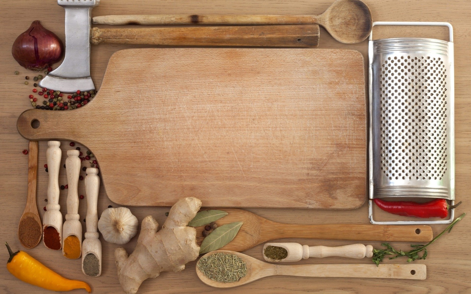 HD PC desktop wallpaper featuring an assortment of herbs, spices, and kitchen tools arranged around a wooden cutting board on a rustic surface.