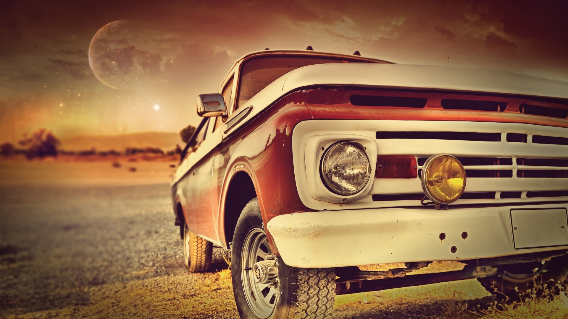 HD desktop wallpaper of a vintage red truck parked on a dusty road with a dramatic sky and distant moon in the background.