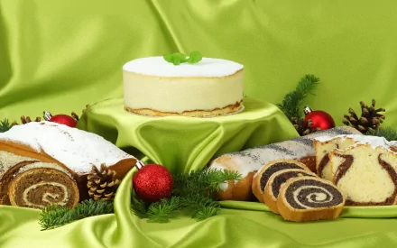 HD desktop wallpaper featuring an assortment of sweet cakes and rolls displayed on green satin fabric with festive decorations.